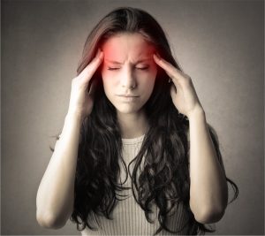 Femme se tenant les tempes, souffrant d'une migraine
